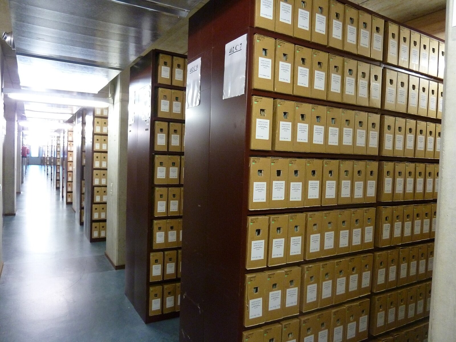 Aisles of numbered cardboard boxes on shelving in the depot of the Dutch National Archives in The Hague