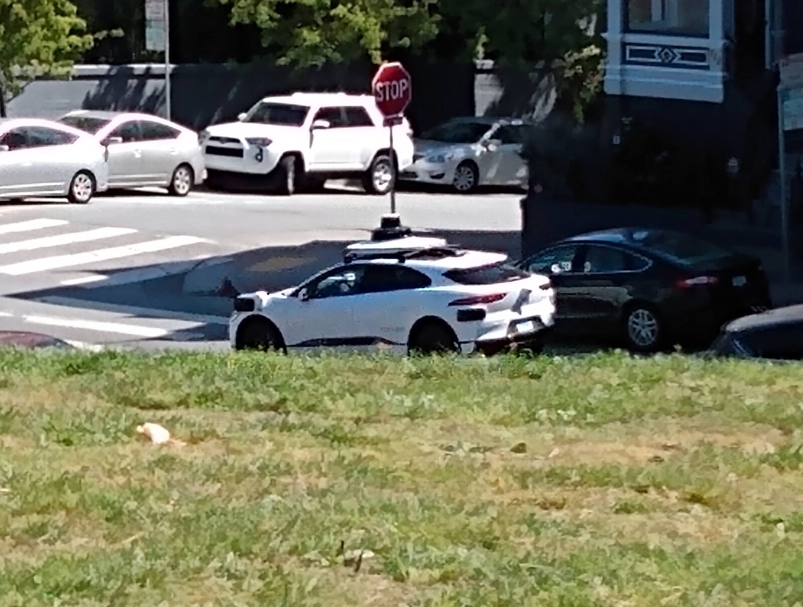 A driverless Waymo Jaguar I-Pace robotaxi on a city street